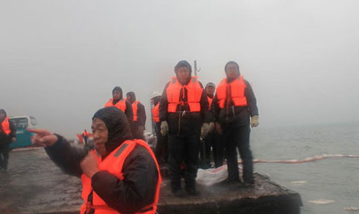 青島華海環保工業有限公司員工冒寒風頂冷雨清理膠州灣溢油